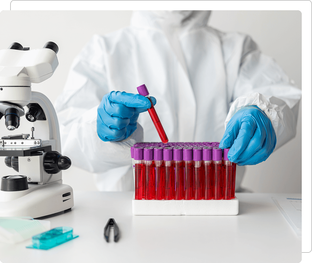 Scientist handling test tubes in a lab.