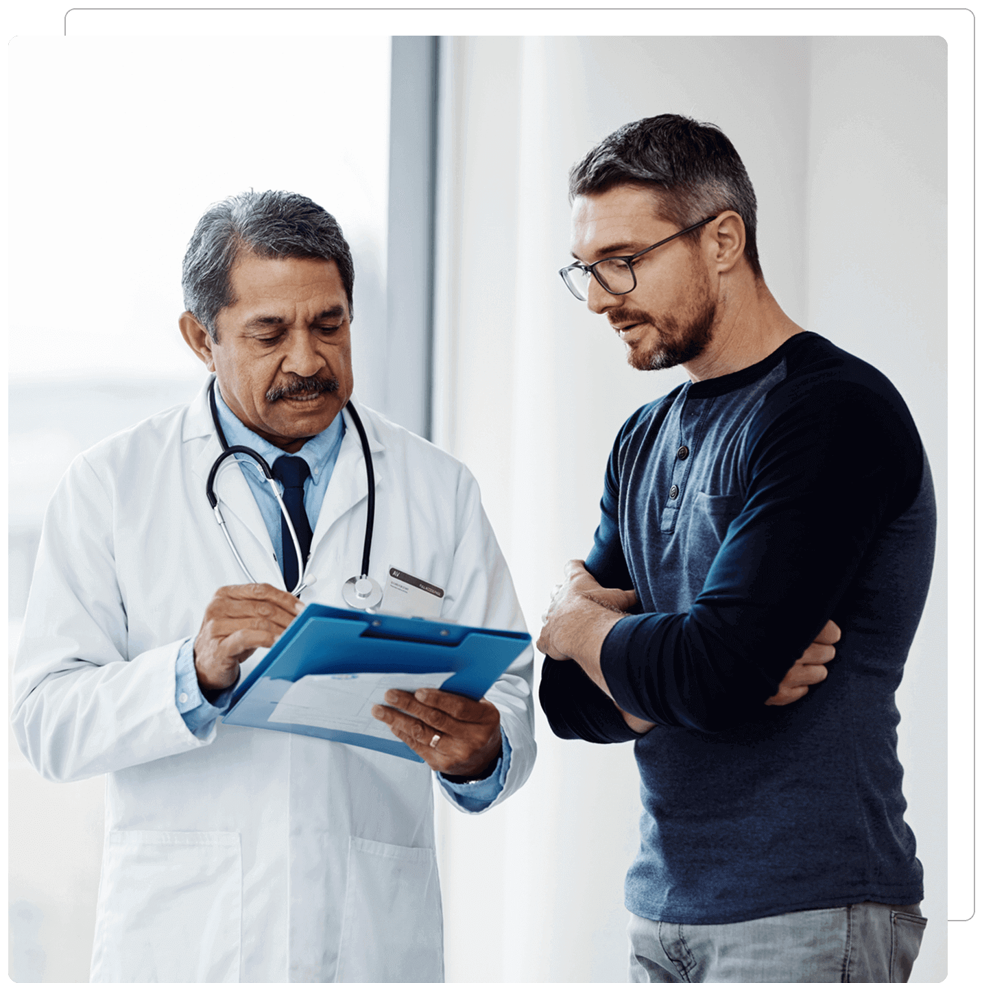Doctor discussing with patient using a clipboard.